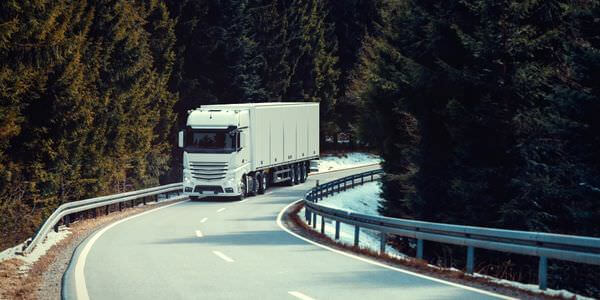 Klaviertransport Bitburg: Lkw fährt auf einer kurvigen Straße durch den Wald
