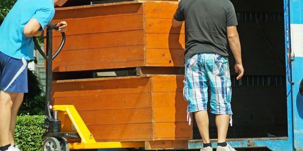 Möbellift Bitburg: Zwei Helfer tragen einen Holzschrank aus einem Lkw